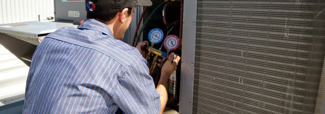 HVAC technician servicing a condenser unit in Channahon