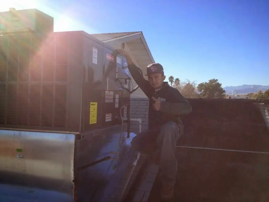 HVAC technician performing HVAC Inspection on a rooftop unit in Channahon